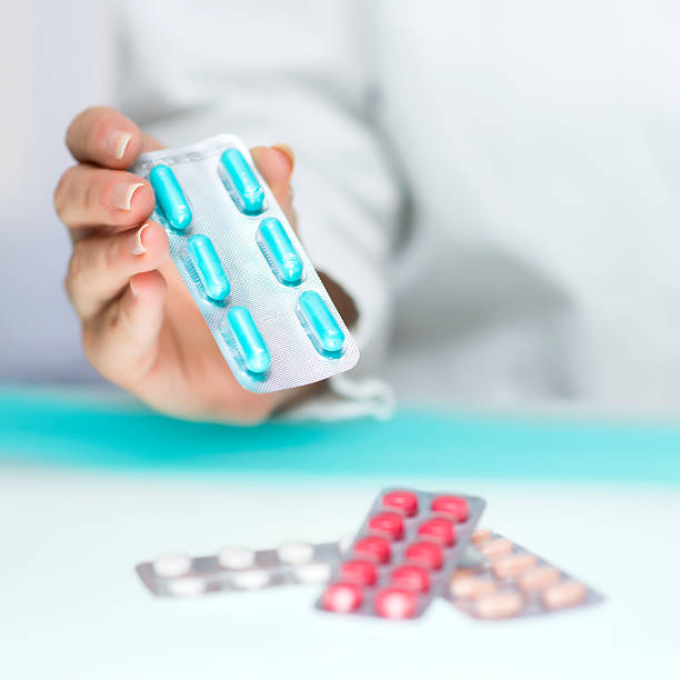 istock Pharmacist holding pills in blister packaging 521758329