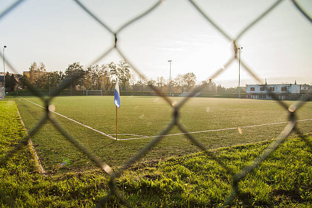 Empty football ground corner with flag and sunset