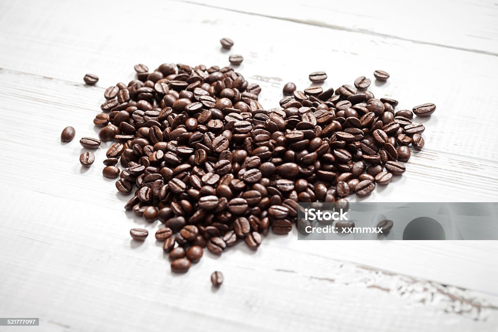 Coffee love Close up of coffee beans heart on old white table. This file is cleaned and retouched. Brown Stock Photo
