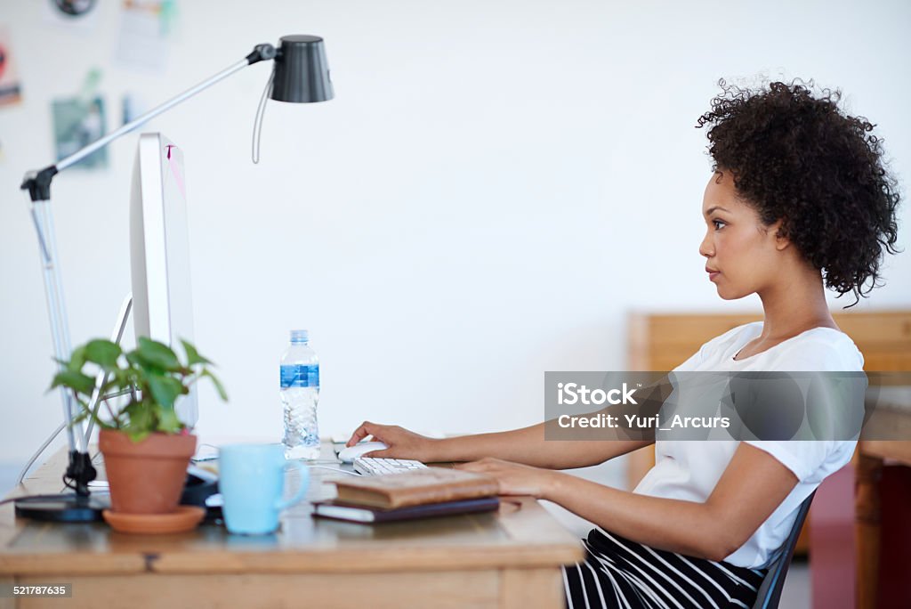 Immersed in her work Shot of an attractive young woman sitting at her workstation in the office. The commercial designs displayed in this image represent a simulation of a real product and have been changed or altered enough by our team of retouching and design specialists so that they are free of any copyright infringements 20-29 Years Stock Photo