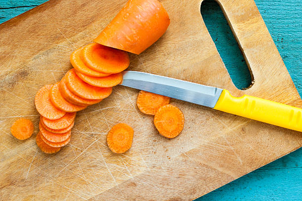 istock fresh carrot and knife on wooden board 521788375