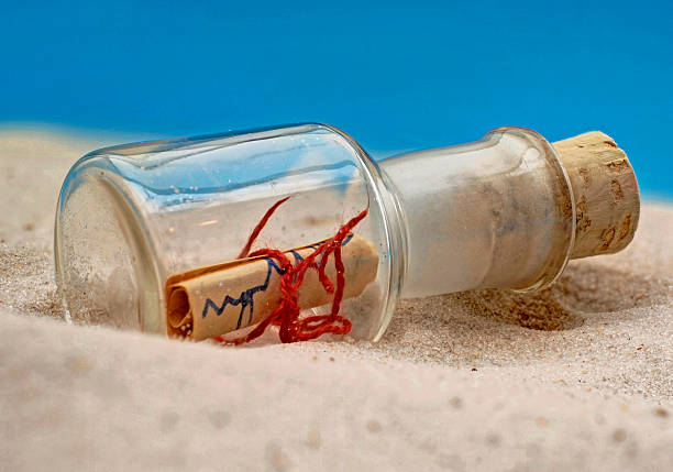 botella con una carta en la playa - meldung fotografías e imágenes de stock