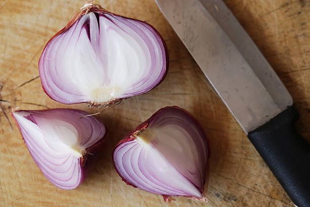 istock Fresh red onions on a wooden background 521794840