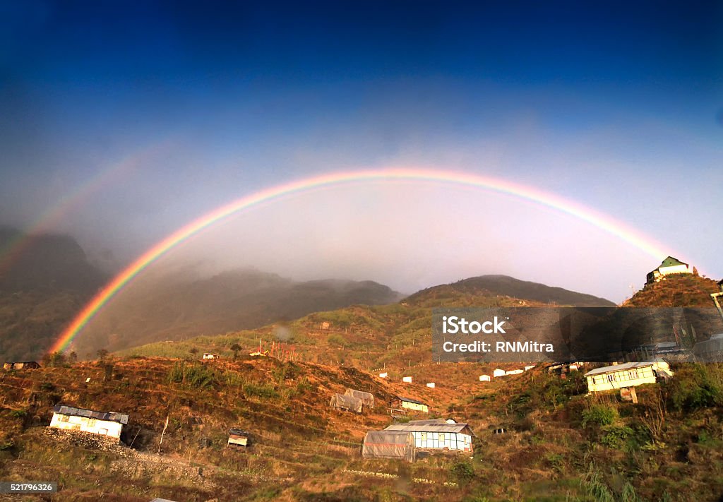 Rainbow over Zuluk village, Sikkim, India Beautiful  rainbow over Zuluk village, Sikkim, West Bengal, India - colourful natural blue sky background Agricultural Field Stock Photo