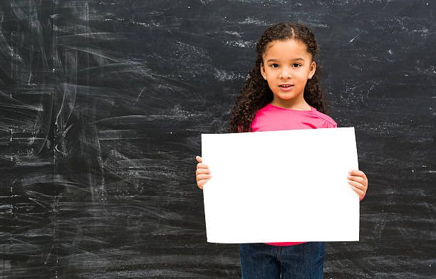 istock little cute girl holding an empty paper sheet 521797608