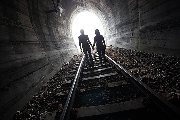 istock Couple walking together through a railway tunnel 521800526