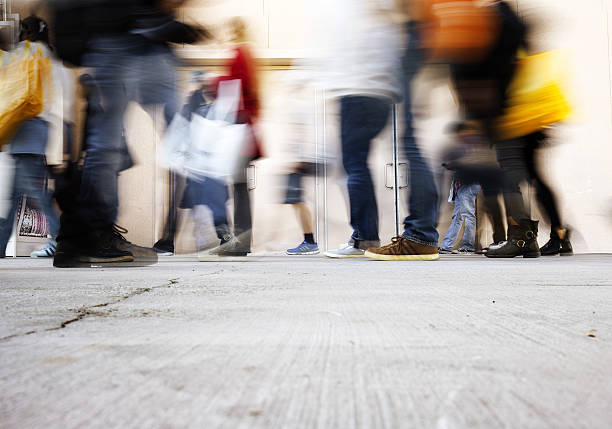 blurry people walking on the sidewalk at rush hour