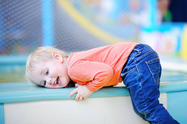 istock Active toddler boy playing at indoors playground 521803320