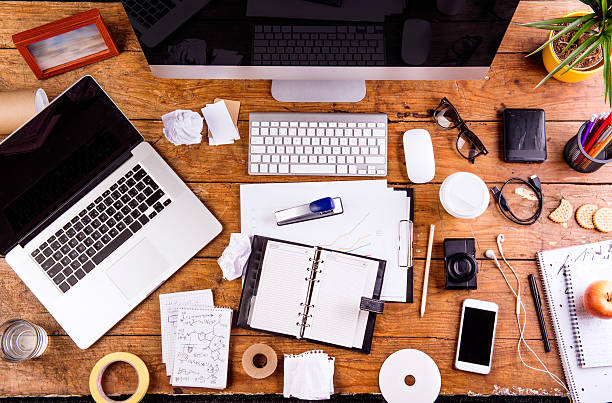 Desk with various gadgets and office supplies. Flat lay Desk with various gadgets and office supplies. Computer, smart phone, notebook and other devices and stationery around the workplace. Flat lay. stapled paper stock pictures, royalty-free photos & images