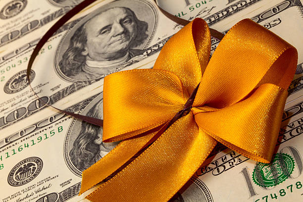 istock Packs of dollar bills with gold bow 521804001