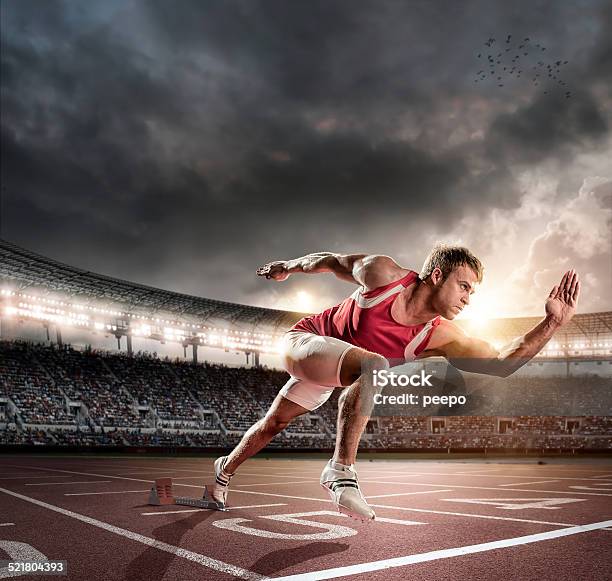 Sprinter Bursting From Starting Blocks On Track Stock Photo - Download Image Now - Running, Stadium, Track And Field
