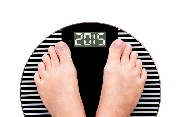 istock 2015 feet on a weight scale isolated on white background 521804671