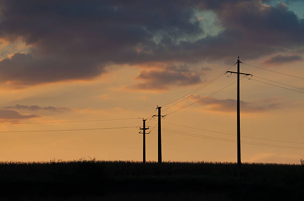 istock sunset and three electric pylons 521805243