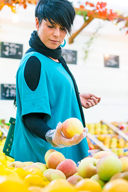 istock Young woman choosing apples 521805337