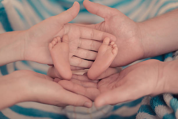 istock Baby feet in parents' hands. 521807553