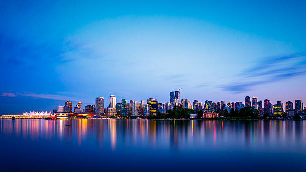 Vancouver City Skyline after Sunset Vancouver skyline at Dusk as seen from Stanley Park, British Columbia, Canada vancouver canada stock pictures, royalty-free photos & images