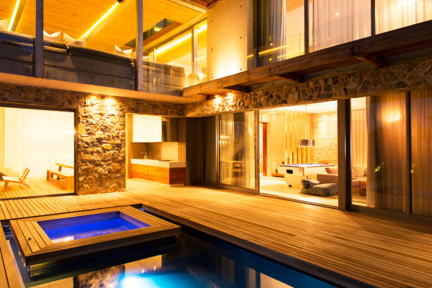 istock Modern house overlooking illuminated swimming pool at night 521810807
