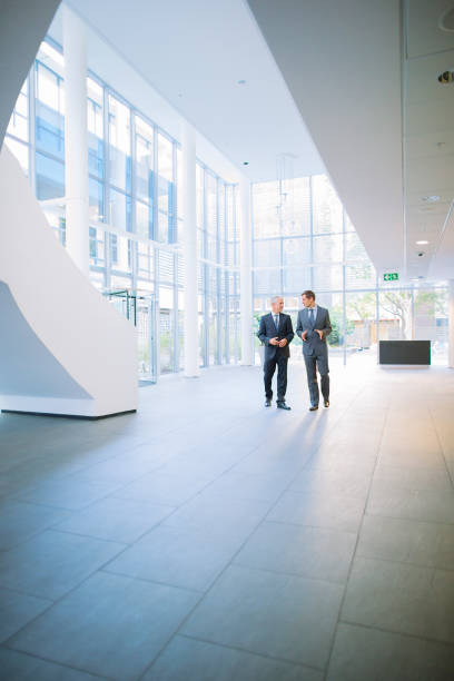 istock Businessmen walking together in office building 521810945