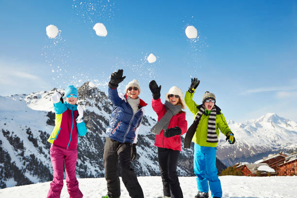 family throwing snowballs on mountain top - group of people teenager snow winter imagens e fotografias de stock