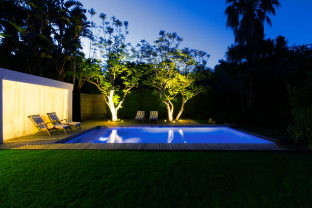 istock Illuminated swimming pool and trees in backyard at dusk 521811179
