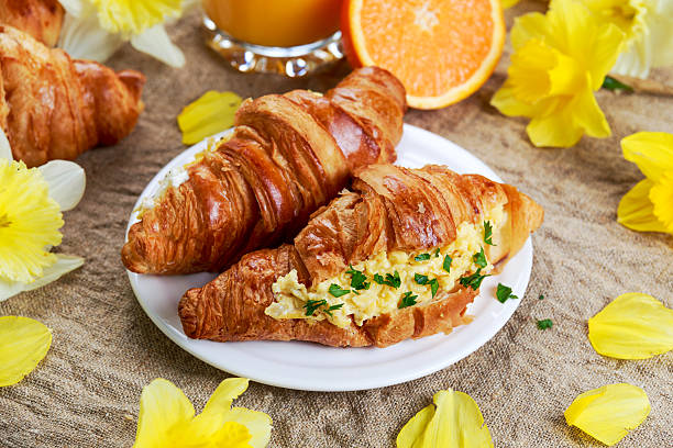 istock Summer Morning Breakfast Croissant stuffed scrambled eggs decorated with flowers. 521811306