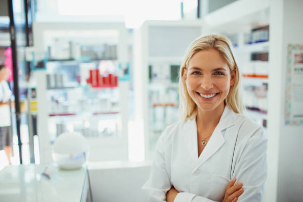 Pharmacist smiling in drugstore stock photo