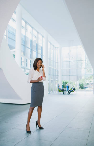 istock Businesswoman talking on cell phone in office building 521811471