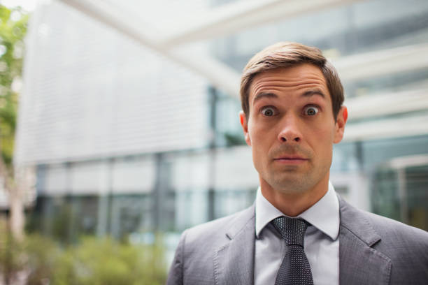 istock Businessman with eyebrows raised outside office building 521811651