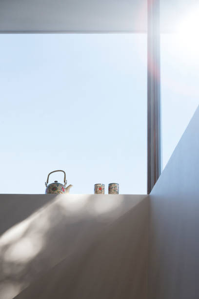 A copy space for displaying your product on a wooden tabletop with a coffee pot and a coffee cup in a minimal bright kitchen. close-up image. 3d render, 3d illustration