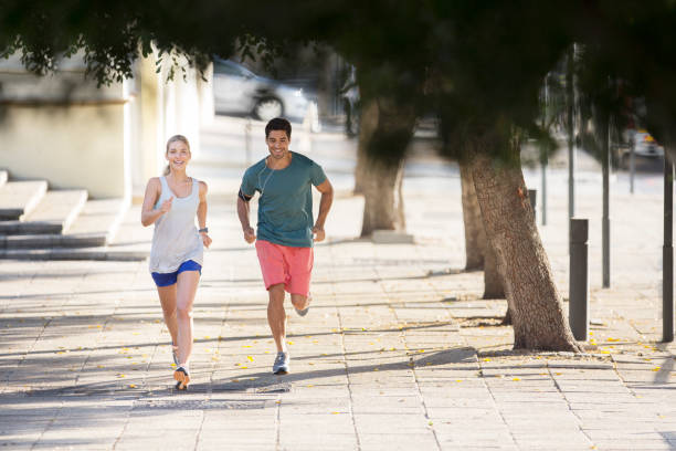 istock Couple running through city streets together 521811997