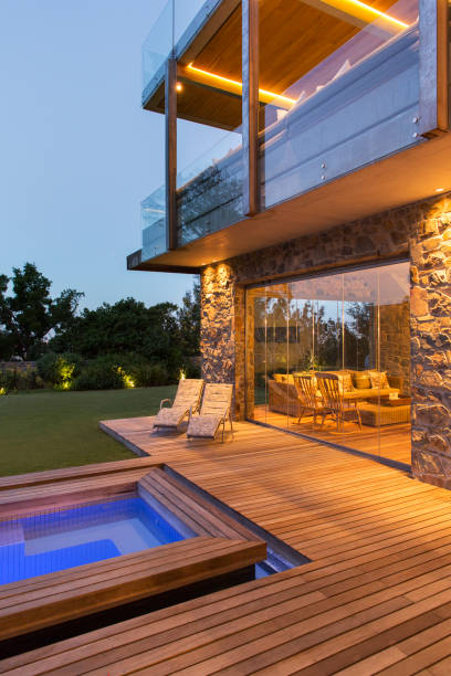 istock Modern house overlooking swimming pool and wooden deck 521812135