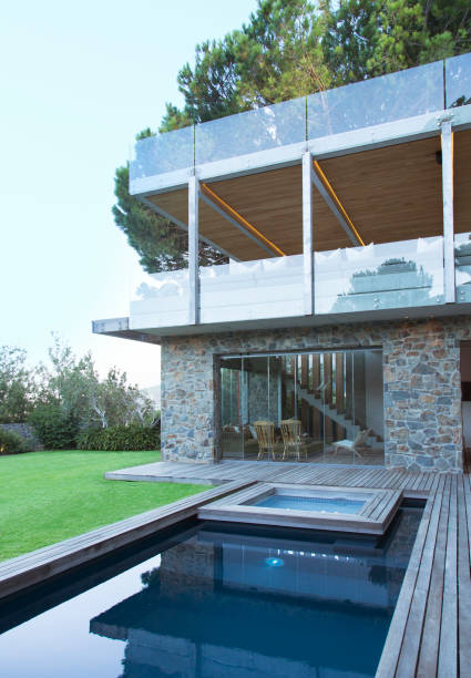 istock Modern house overlooking swimming pool and wooden deck 521812173