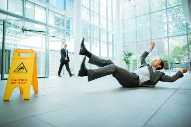 Businessman slipping on floor of office building stock photo