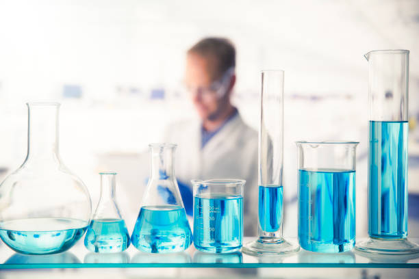 istock Close up of various solutions in beakers on shelf in lab 521812251
