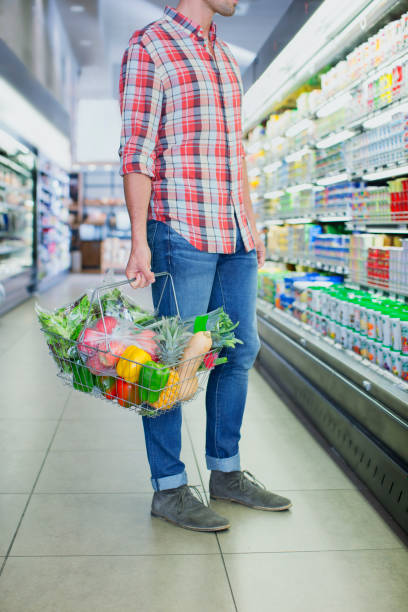 istock Man carrying full shopping basket in grocery store 521812955