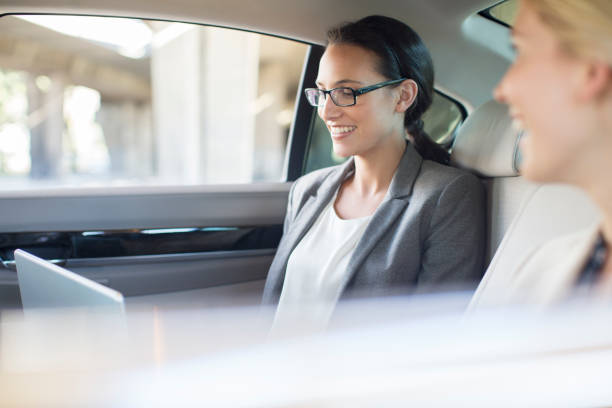 istock Businesswomen working in car back seat 521812969