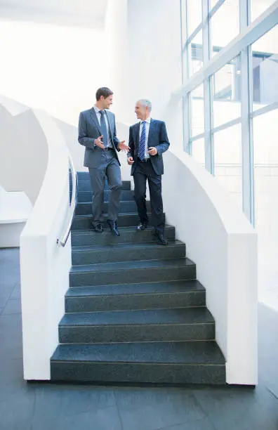 Photo of Businessmen talking on stairs