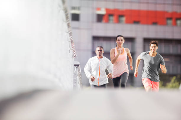 istock Friends running through city streets together 521813213