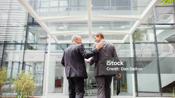 Businessmen Walking Into Office Building Together Stock Photo - Download Image Now - Walking, Building Exterior, Office Building Exterior