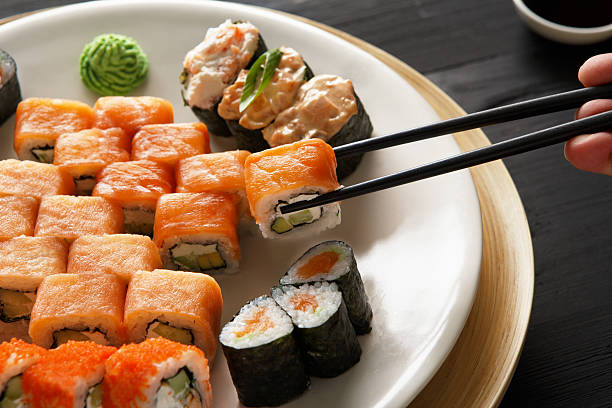 istock Eating sushi rolls at japanese food restaurant 521813390