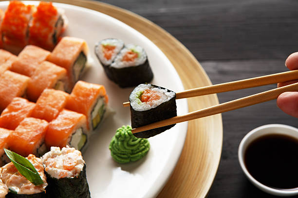 istock Eating sushi rolls at japanese food restaurant 521813508