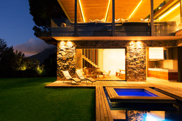 istock Modern house overlooking illuminated swimming pool at night 521813515