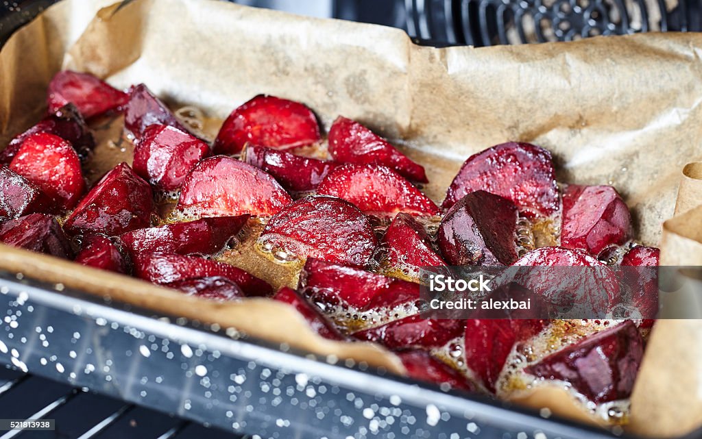 Baked beet inside oven Baked beet with olive oil and salt inside oven in black pan with parchment paper Baked Stock Photo
