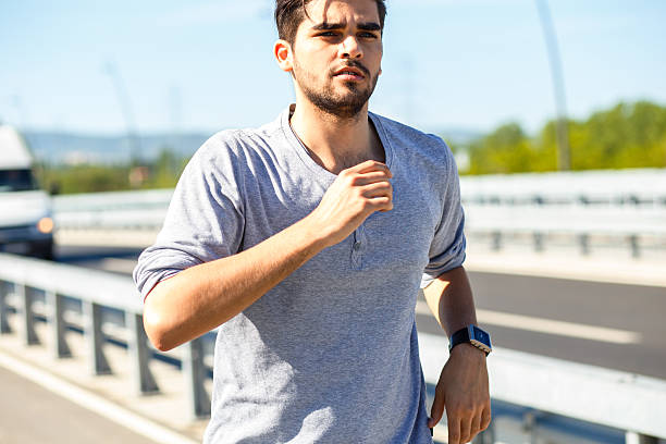 istock Young man jogging in urban environment 521814586