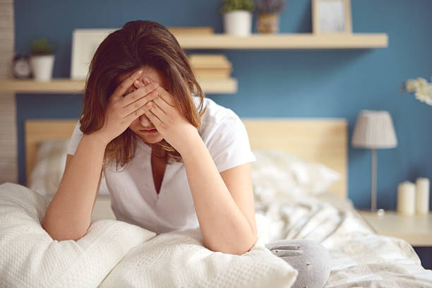 infelice ragazza in una camera da letto - women sadness depression fear foto e immagini stock