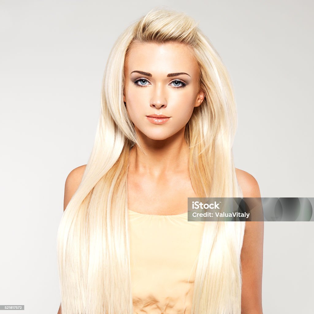 Blond woman with long straight hair Beautiful woman with long straight blond hair. Fashion model posing at studio. Blond Hair Stock Photo