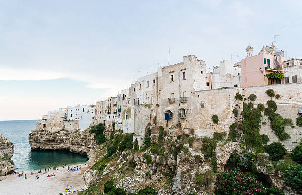 Tranquil turquoise waters lap against the rocky shore beneath the charming town of vieste on the gargano promontory, a popular travel destination in puglia, italy