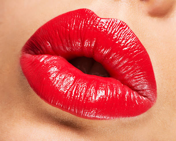 istock Woman's lips with red lipstick and  kiss gesture 521819134