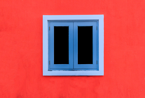 window on a red wall on the street