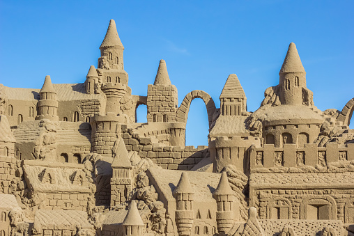 Sand castle with many towers against a blue sky